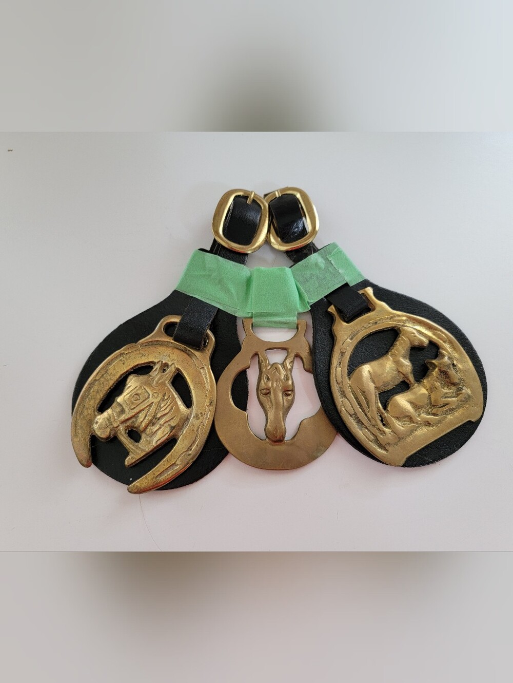 Vintage decorative horse brasses mounted on black leather straps
